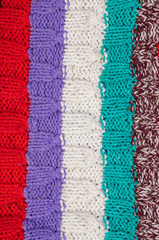 Knitted multi-colored texture. Background knitted stripes close-up.