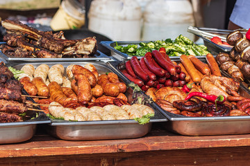 Culinary Buffet with healthy take away meal - grilled vegetables, fish and meat on the street food culinary market, festival, event.  Different types of delicious meat. Outdoor Cuisine. 
