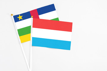 Luxembourg and Central African Republic stick flags on white background. High quality fabric, miniature national flag. Peaceful global concept.White floor for copy space.