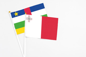 Malta and Central African Republic stick flags on white background. High quality fabric, miniature national flag. Peaceful global concept.White floor for copy space.