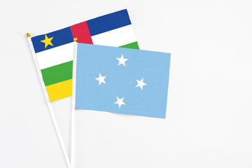 Micronesia and Central African Republic stick flags on white background. High quality fabric, miniature national flag. Peaceful global concept.White floor for copy space.