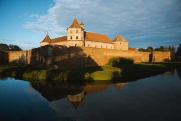 Naklejka premium Beautiful medieval castle with river at sunset somewhere in Romania