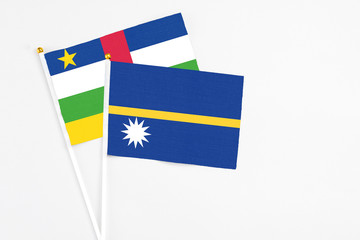 Nauru and Central African Republic stick flags on white background. High quality fabric, miniature national flag. Peaceful global concept.White floor for copy space.
