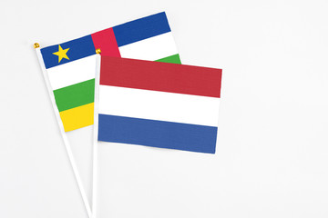 Netherlands and Central African Republic stick flags on white background. High quality fabric, miniature national flag. Peaceful global concept.White floor for copy space.