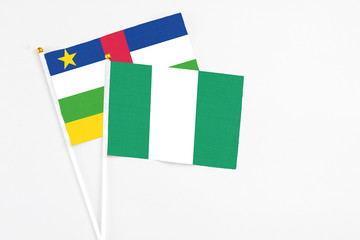 Nigeria and Central African Republic stick flags on white background. High quality fabric, miniature national flag. Peaceful global concept.White floor for copy space.