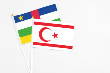 Northern Cyprus and Central African Republic stick flags on white background. High quality fabric, miniature national flag. Peaceful global concept.White floor for copy space.