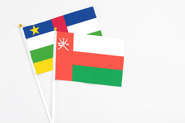 Oman and Central African Republic stick flags on white background. High quality fabric, miniature national flag. Peaceful global concept.White floor for copy space.