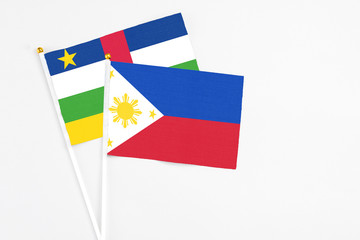 Philippines and Central African Republic stick flags on white background. High quality fabric, miniature national flag. Peaceful global concept.White floor for copy space.