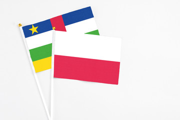 Poland and Central African Republic stick flags on white background. High quality fabric, miniature national flag. Peaceful global concept.White floor for copy space.