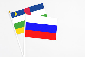 Russia and Central African Republic stick flags on white background. High quality fabric, miniature national flag. Peaceful global concept.White floor for copy space.