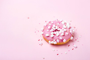 Pink donut with marshmallows and sprinkled. Minimal concept