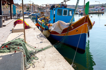 Fototapeta na wymiar Marsaxlokk. Traditional boats Luzzu in the old harbor.