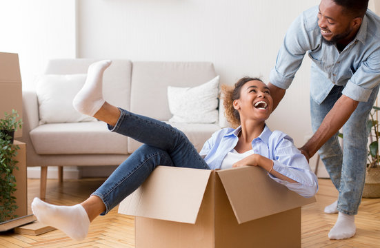 Black Man Riding Girlfriend In Moving Box In New Apartment