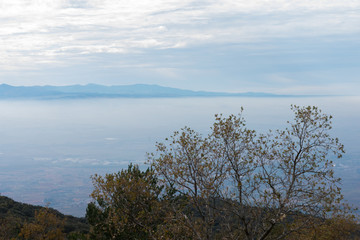 valley covered by clouds of fog between mountains