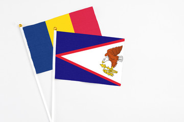 American Samoa and Chad stick flags on white background. High quality fabric, miniature national flag. Peaceful global concept.White floor for copy space.