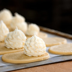 Finished production raw sochniki sochni with cottage cheese in factory in the steel table. Traditional Russian shortbread with cottage cheese. Working process. Private bakery.