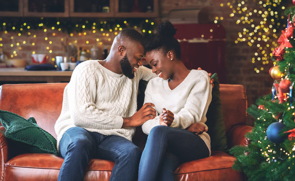 Romantic african american couple celebrating Christmas together at home