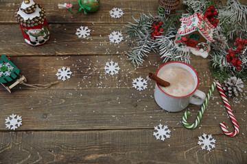 christmas background with gingerbread cookies, cup of cocoa, caramel canes gingerbread house and decorations on wooden background with copy space for text. Top view.