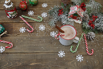 christmas composition with gingerbread cookies, cup of cocoa, caramel canes gingerbread house and decorations on wooden background with copy space for text. Top view