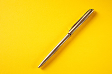 metal pen isolated on yellow background