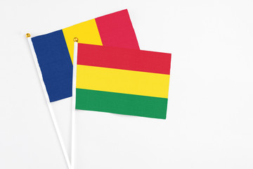 Bolivia and Chad stick flags on white background. High quality fabric, miniature national flag. Peaceful global concept.White floor for copy space.