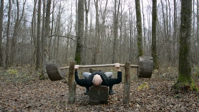 Exercising in the spring forest, lifting the bar, training in the fresh air hd stock footage