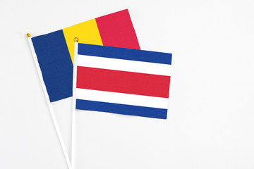 Costa Rica and Chad stick flags on white background. High quality fabric, miniature national flag. Peaceful global concept.White floor for copy space.