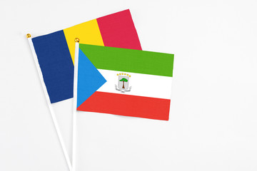 Equatorial Guinea and Chad stick flags on white background. High quality fabric, miniature national flag. Peaceful global concept.White floor for copy space.