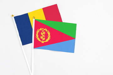 Eritrea and Chad stick flags on white background. High quality fabric, miniature national flag. Peaceful global concept.White floor for copy space.