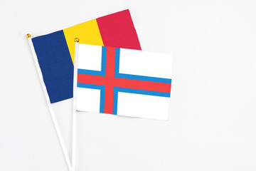 Faroe Islands and Chad stick flags on white background. High quality fabric, miniature national flag. Peaceful global concept.White floor for copy space.