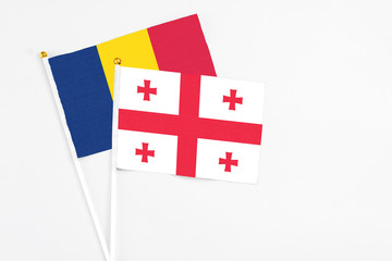 Georgia and Chad stick flags on white background. High quality fabric, miniature national flag. Peaceful global concept.White floor for copy space.