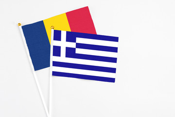 Greece and Chad stick flags on white background. High quality fabric, miniature national flag. Peaceful global concept.White floor for copy space.