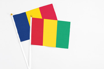 Guinea and Chad stick flags on white background. High quality fabric, miniature national flag. Peaceful global concept.White floor for copy space.