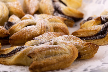 Gef&uuml;llte Windr&auml;der mit Nuss-Nougat-Creme aus Bl&auml;tterteig auf Tortenspitze