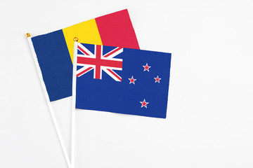 Fototapeta premium New Zealand and Chad stick flags on white background. High quality fabric, miniature national flag. Peaceful global concept.White floor for copy space.