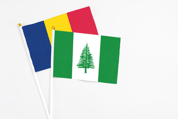 Norfolk Island and Chad stick flags on white background. High quality fabric, miniature national flag. Peaceful global concept.White floor for copy space.