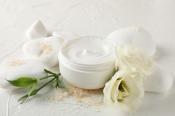 Fototapeta na wymiar Stones, cream, salt and flowers on white background, close up