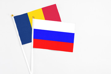 Russia and Chad stick flags on white background. High quality fabric, miniature national flag. Peaceful global concept.White floor for copy space.
