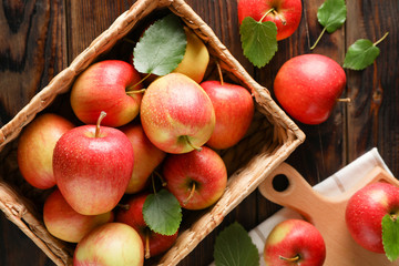 Basket with apples on wooden background, top view