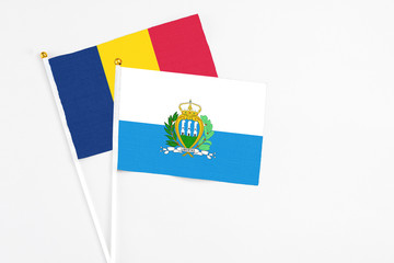 San Marino and Chad stick flags on white background. High quality fabric, miniature national flag. Peaceful global concept.White floor for copy space.