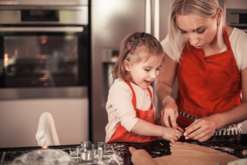 Mom and little daughter bake Christmas cookies. Family cooks in the kitchen. Holidays. Christmas....