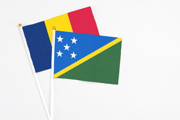 Solomon Islands and Chad stick flags on white background. High quality fabric, miniature national flag. Peaceful global concept.White floor for copy space.