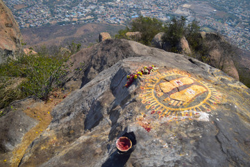 Feet symbol at the top view of Tiruvannamalai city and Arunacheshvara Temple from Arunachala hill with two travellers going down, Tamil Nadu India