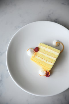 Yellow sponge cake slice with raspberries and cream