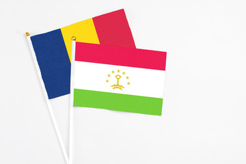 Tajikistan and Chad stick flags on white background. High quality fabric, miniature national flag. Peaceful global concept.White floor for copy space.