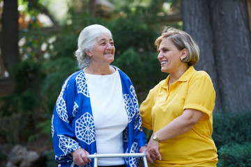 Health visitor and a senior woman during visit, outdoors