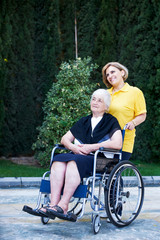 Obraz premium Professional caregiver taking care of senior woman, outdoors.
