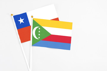 Comoros and Chile stick flags on white background. High quality fabric, miniature national flag. Peaceful global concept.White floor for copy space.