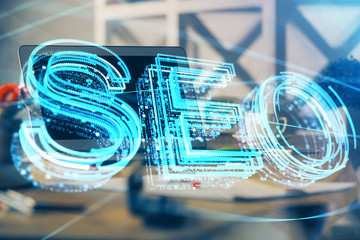 Multi exposure of table with computer and seo drawing hologram. Search optimization concept.