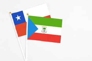 Equatorial Guinea and Chile stick flags on white background. High quality fabric, miniature national flag. Peaceful global concept.White floor for copy space.
